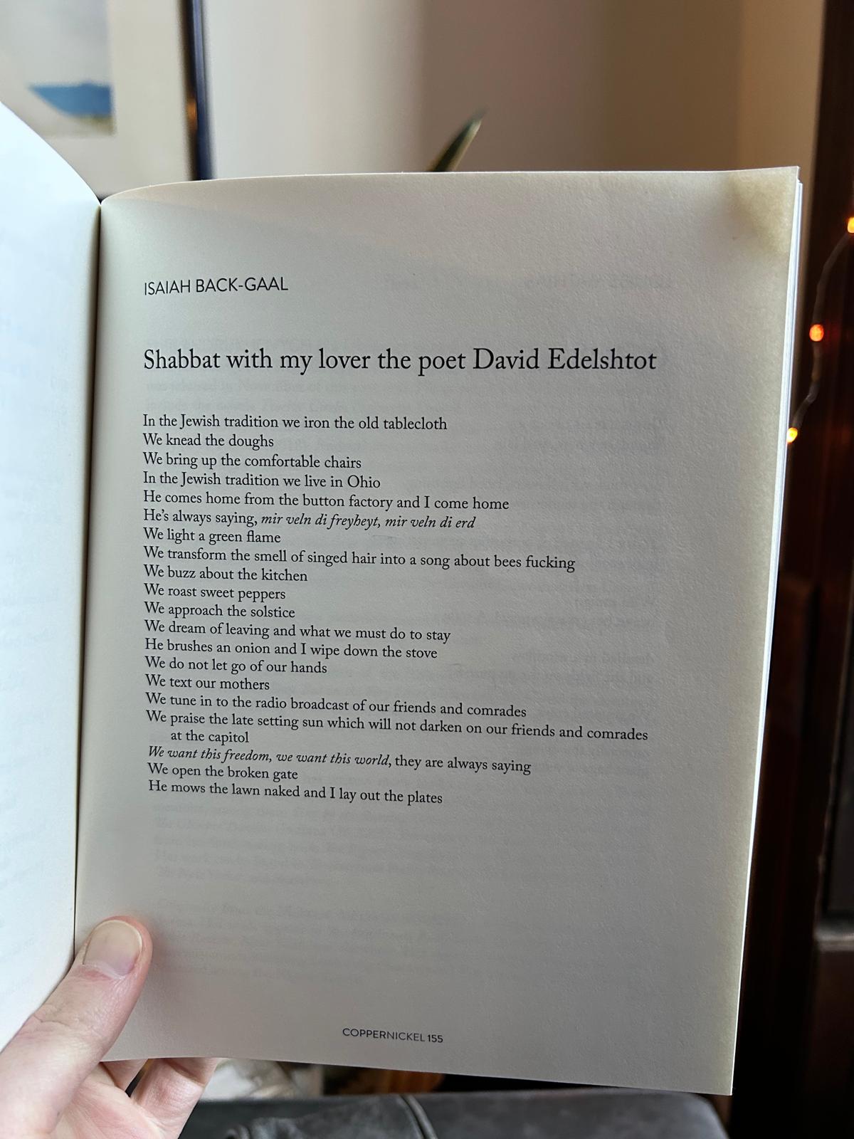 Picture of a poem called "Shabbat with my lover the poet Dovid Edelshtot," published in an issue of Copper Nickel magazine. You can see Isaiah's thumb holding the page of the magazine.